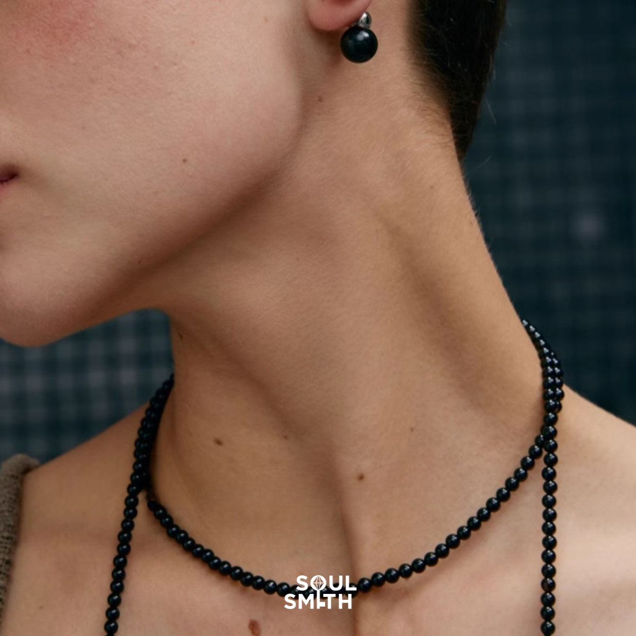 Model wearing SoulLinks Collection black onyx jewelry by SoulSmith — featuring minimalist beaded necklace and matching stud earring, symbolizing grounding and inner strength.