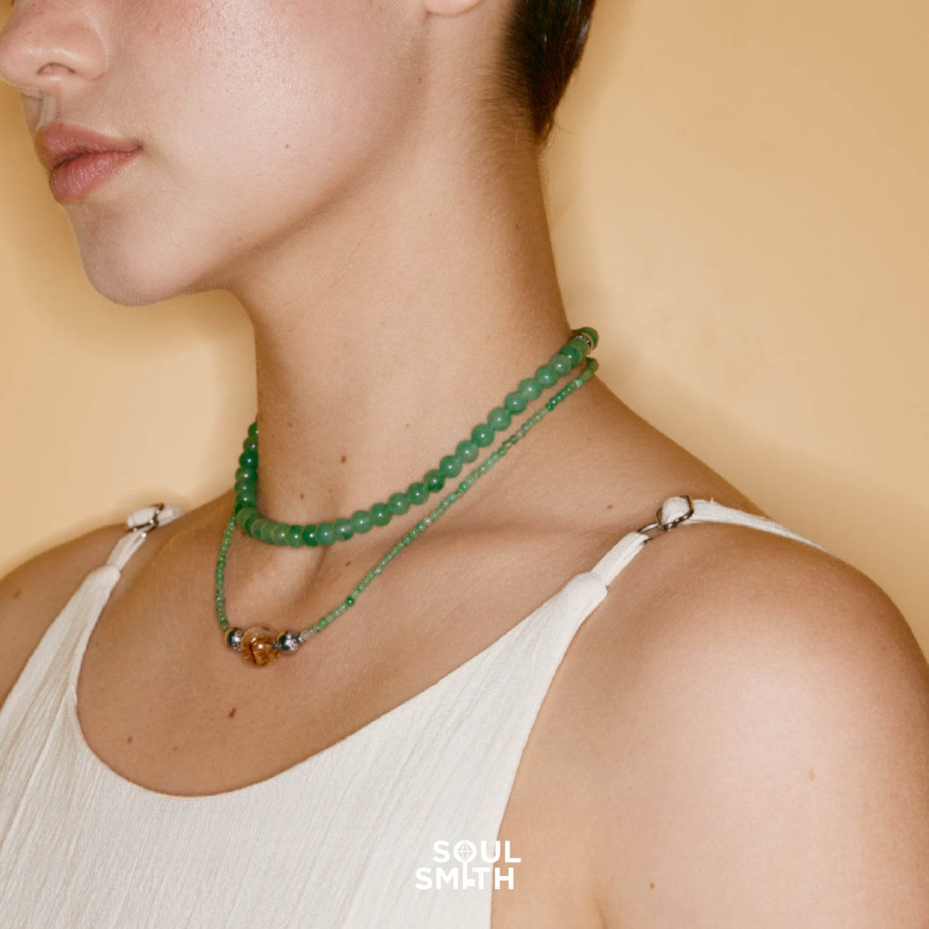 Layered green aventurine and citrine bead necklaces worn by woman, Soulsmith handcrafted jewelry supporting heart and solar plexus chakra alignment.