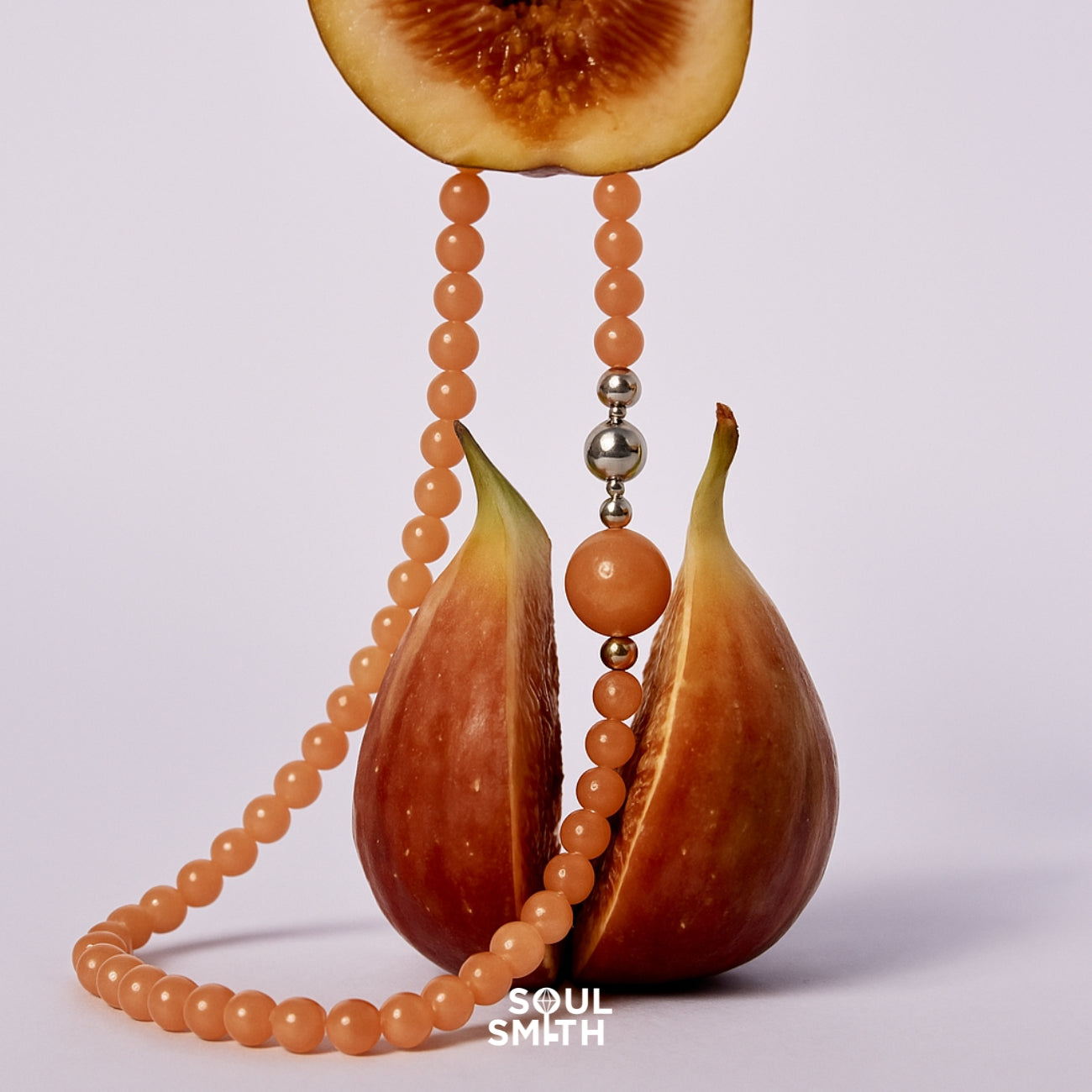 SOULSMITH Soullinks peach moonstone healing necklace styled with fresh figs — crystal beaded jewelry for heart chakra balance and gentle feminine energy