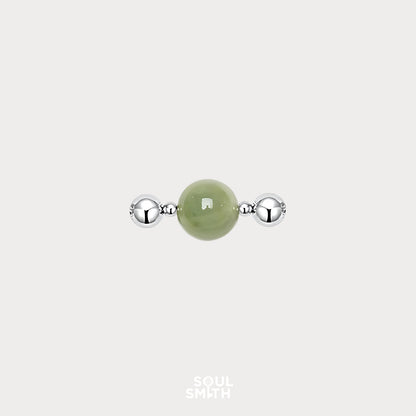 Berylite charm bead for Heart Chakra balance, featuring a soft green gemstone flanked by polished silver accents.
