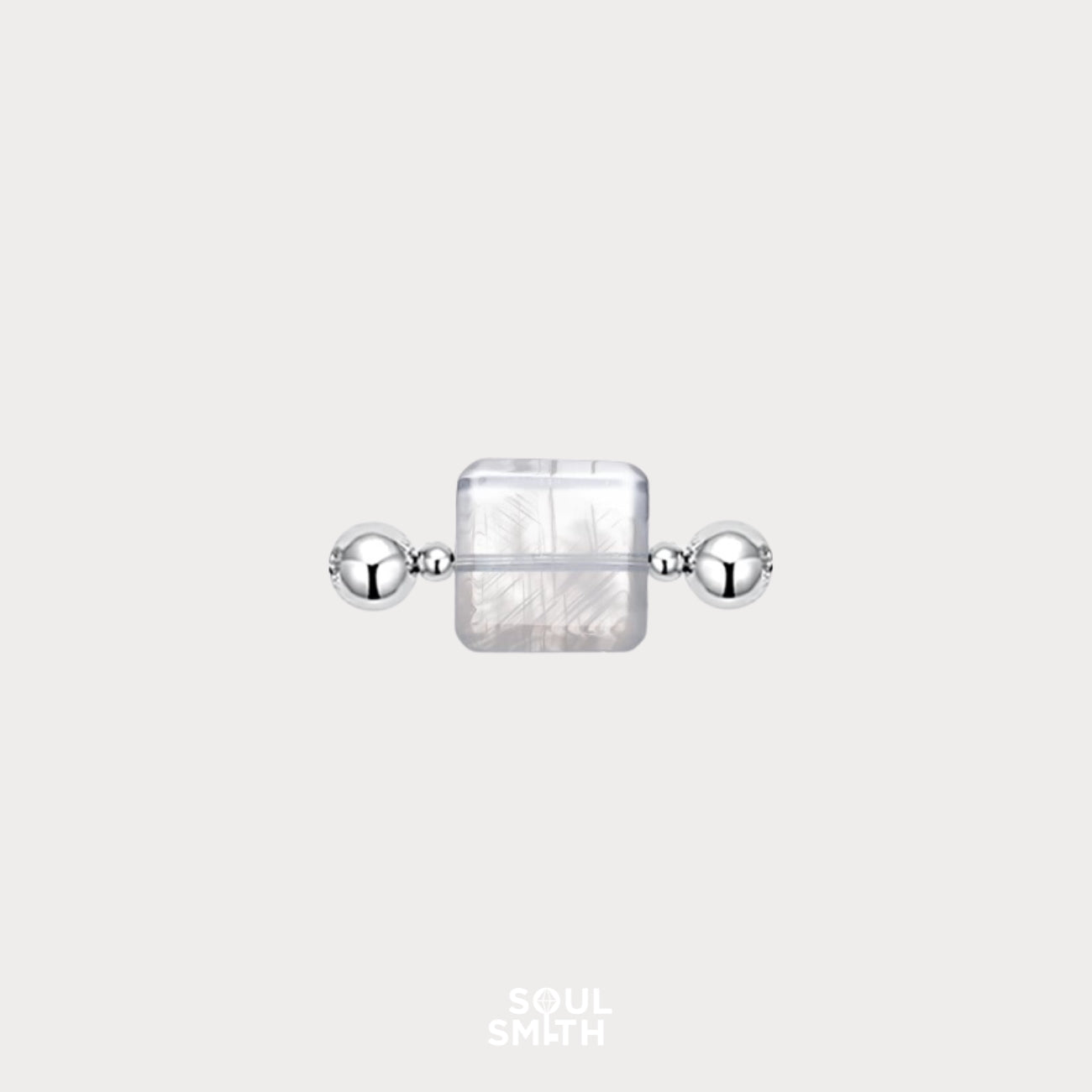 Square-cut Blue Needle Crystal charm flanked by polished silver beads, showcasing delicate thread-like inclusions in a translucent, icy base — an ethereal element from the Soulsmith SoulLinks collection.

