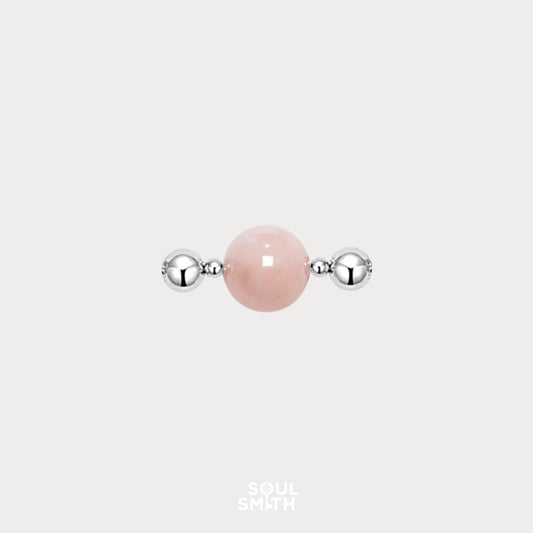 Polished Pink Morganite charm bead flanked by two shiny silver-toned spacers, set against a light grey background.