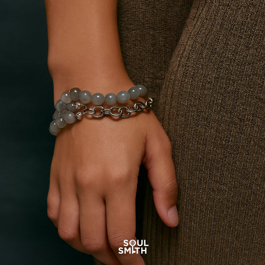 Close-up of hand wearing Soul Smith gray moonstone crystal bracelet with silver chain, promoting calm and modern style