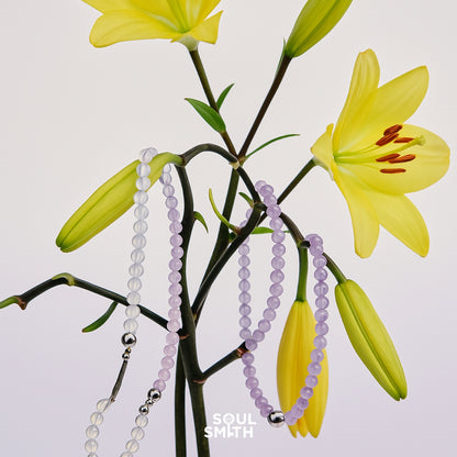 Crown chakra bracelets in amethyst and moonstone, draped on blooming lilies – SoulSmith
