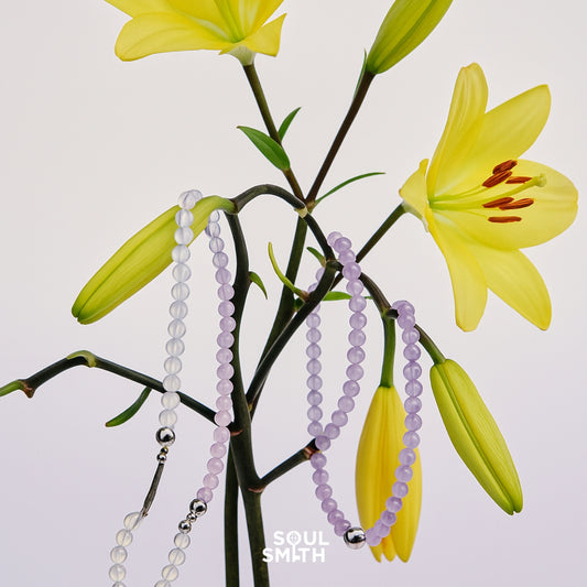 Crown chakra bracelets in amethyst and moonstone, draped on blooming lilies – SoulSmith

