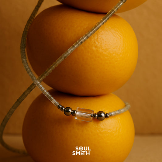 Minimalist grey moonstone and clear quartz necklace for crown chakra, styled on oranges – SoulSmith jewelry
