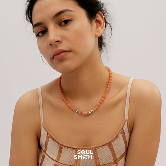 Woman wearing orange moonstone necklace for sacral chakra energy boost
