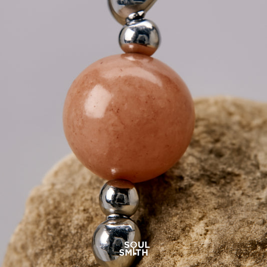 Orange moonstone bead for sacral chakra balance, close-up on natural stone surface
