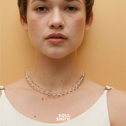 Model wearing a Soulsmith Clear Quartz bracelet styled as a choker necklace, featuring round, transparent crystal beads for crown chakra alignment and spiritual clarity.

